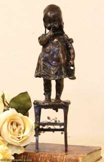 this bronze sculpture of a little girl standing on a stool is after a 