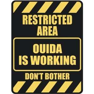  RESTRICTED AREA OUIDA IS WORKING  PARKING SIGN